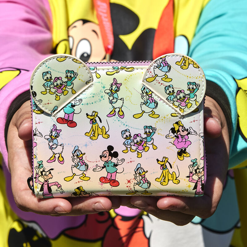 Person holding our Loungefly Disney100 Mickey & Friends Classic All-Over Print Iridescent Zip Around Wallet toward the camera 